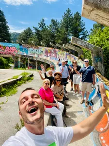 A tour group waving at the abandoned Olympic bobsled track