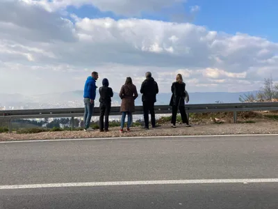A tour group looking out over Sarajevo from a mountain road