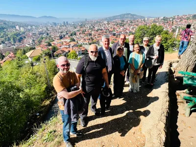A tour group posing above Sarajevo on a sunny day