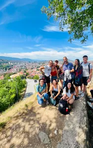 A tour group posing above the Sarajevo city skyline