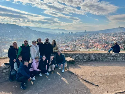 A tour group posing at the Yellow Fortress viewpoint above Sarajevo