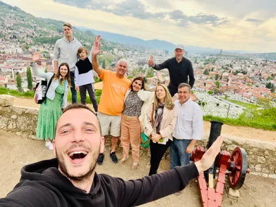 A tour group taking a cheerful selfie above Sarajevo