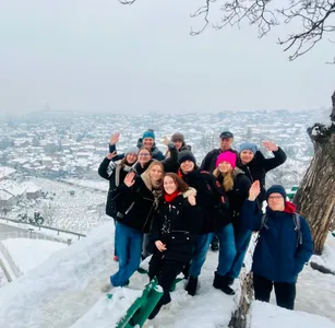 A tour group waving above a snowy Sarajevo