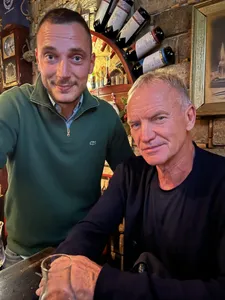 A tour guide and Sting posing inside a Sarajevo restaurant