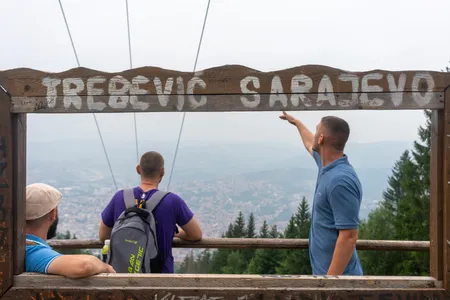 A tour guide pointing out Sarajevo from the Trebevic viewpoint