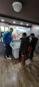 A tour guide showing visitors a Sarajevo siege museum display