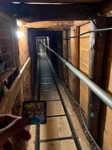 A visitor holding an Art and Tours magnet inside the Sarajevo Tunnel of Hope