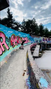 A visitor walking along the graffiti covered Olympic bobsled track