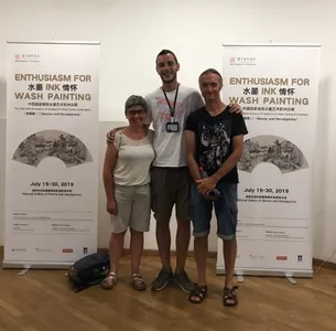 Three people posing at an ink wash painting exhibition in Sarajevo