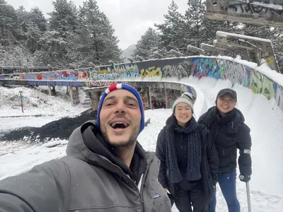 Three people taking a selfie at the snowy Olympic bobsled track