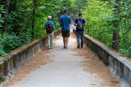 Three visitors walking along the Olympic bobsled track